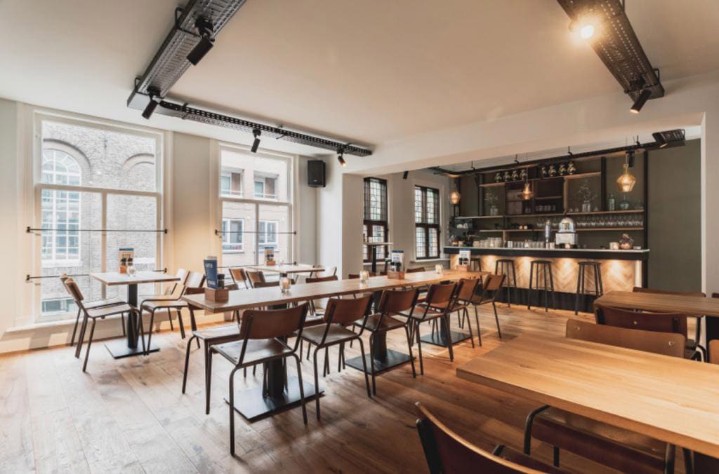 De Private Dining ruimte boven het restaurant, met lange tafels bij hoge ramen en een eigen bar